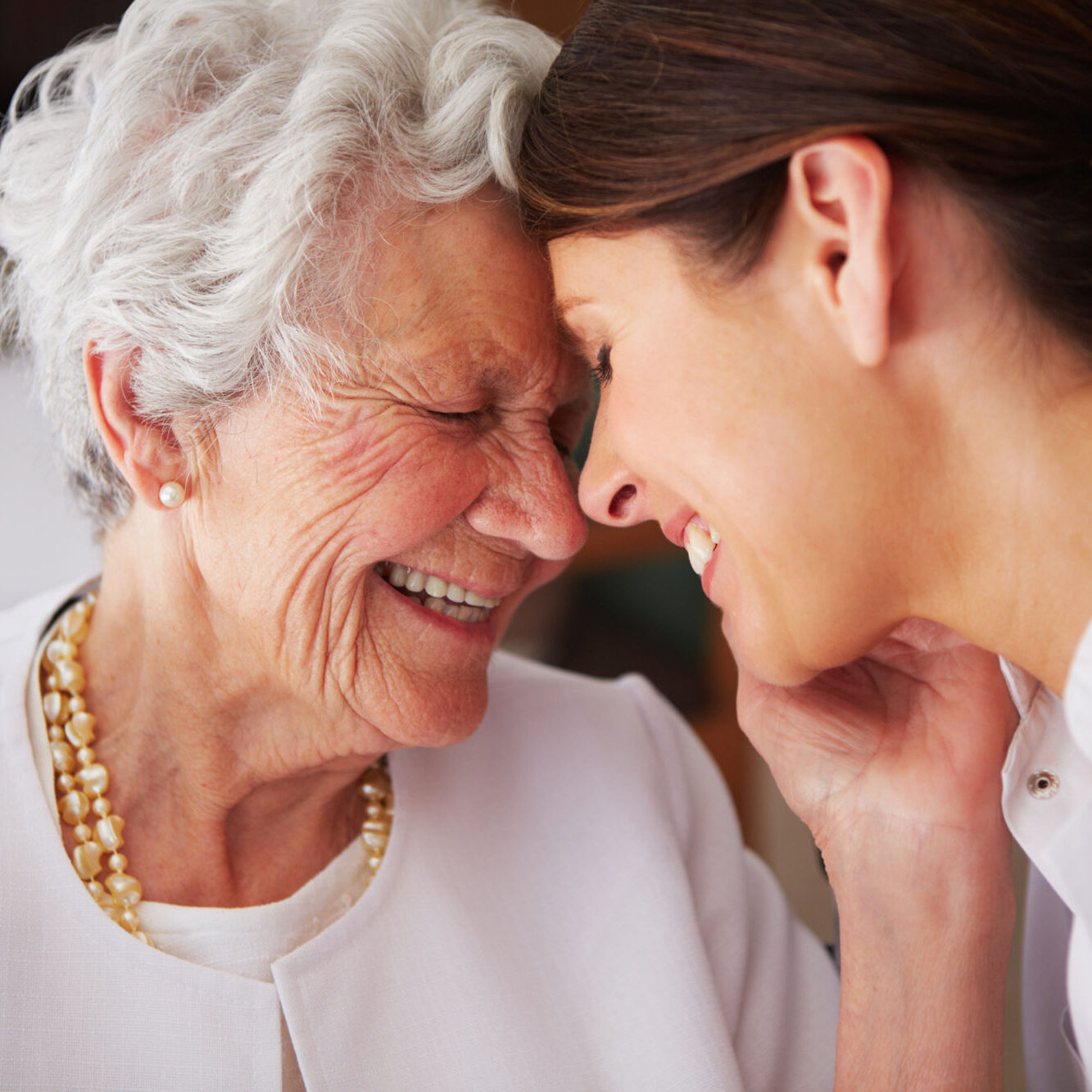 An elderly woman affectionately thanking her nurse